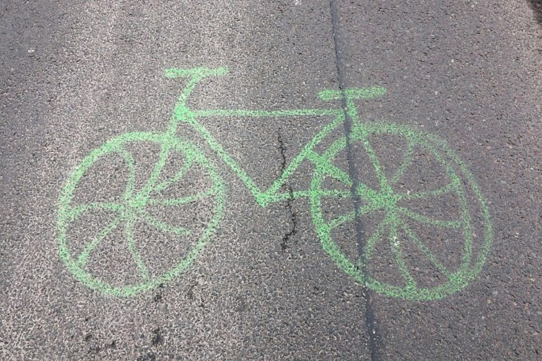 Grünes Radsymbol auf Asphalt.