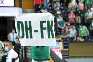 Ein Fan hält ein weißes Schild mit den grünen Buchstaben "DH-FK" hoch. Foto: Jan Kaefer