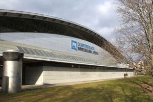 Außenansicht der Quarterback Immobilien Arena Leipzig. Stirnseite mit geschwungenem Dach und dem Arena-Logo. Foto: Jan Kaefer