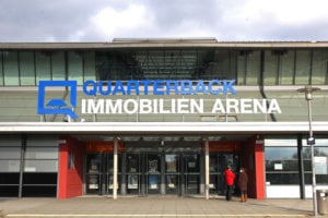 Blick auf den Eingang der Quarterback Immobilien Arena Leipzig mit Schriftzug und Logo. Foto: Jan Kaefer