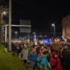 Menschenzug marschiert auf einer Straße.