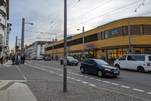 Straßenkreuzung und Konsummarkt, fahrende Autos.