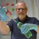 Mann mit Handschuhen und Wasserprobe im Labor.