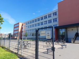 Schulgebäude mit Pausenhof von außen.