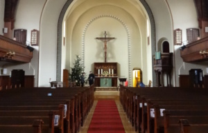 Blick zum Altar einer Kirche mit Christuskreuz.