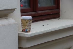 Kaffeebecher auf Fensterbrett.