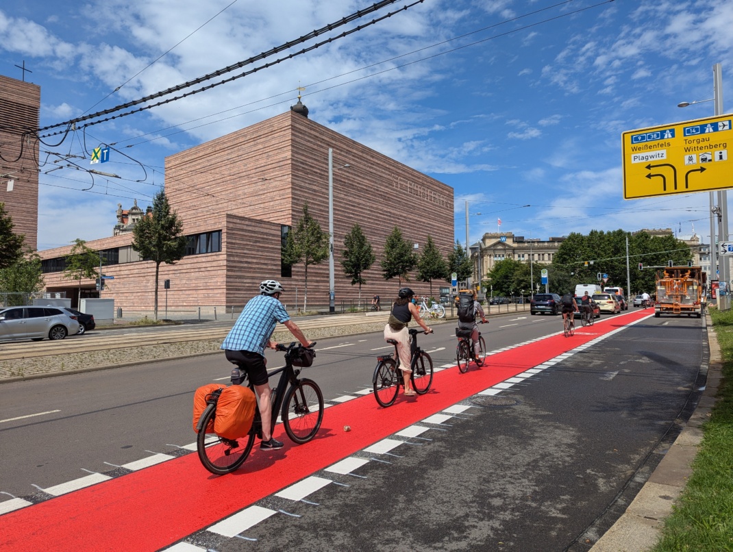 Fahrradfahrer fahren über die neu eingefärbte Fahrradspur am Wilhelm-Leuschner-Platz in Leipzig.