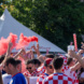 Kroatische Fußball-Fans beim Fanmarsch am 24. Juni 2024 in Leipzig, zu sehen sind Rauchfackeln und Plastikbecher, die in die Höhe gereckt werden.