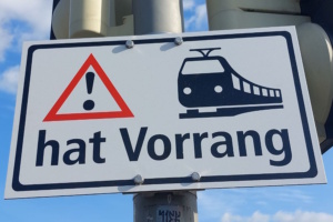 Verkehrsschild, welches der Straßenbahn Vorrang einräumt, Aufnahme in schrägem Winkel von unten.