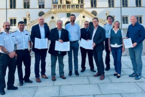 Die Bürgermeister René Vetter (Beilrode), Holger Reinboth (Arzberg), Ingolf Gläser (Belgern-Schildau) sowie Torgaus Oberbürgermeister Henrik Simon (von links) mit den Zuwendungsbescheiden im Hof von Schloss Hartenfels in Torgau. In der Mitte der 2. Beigeordnete des Landkreises Nordsachsen, Jens Kabisch. Foto: LRA