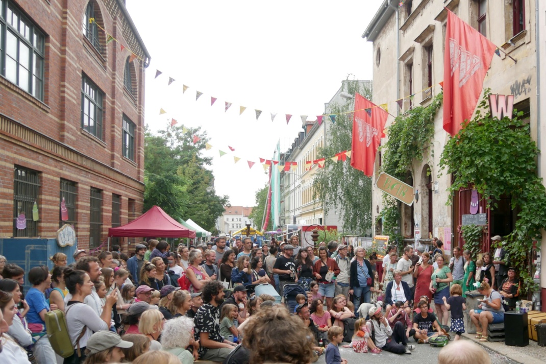 Menschen beim Sommerfest auf der Straße sitzend