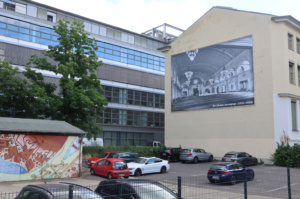 Parkplatz mit Autos und Hauswand.