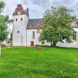 Kirche auf grünem Hügel.