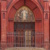 Rotfarbenes Kirchgebäude, Portal mit Christusdarstellung.