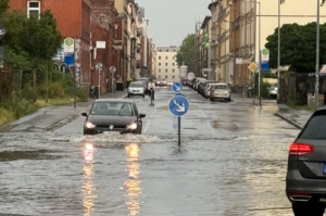 Überschwemmte Straße in der Stadt und PKW.