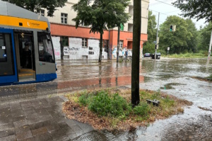 Starkregen, Bahn auf überfluteter Straße.