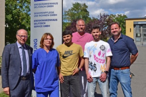 Steffen Penndorf (Geschäftsführer Kreiskrankenhaus Delitzsch), Manuela Weidlich (Pflegedienst-Leitung), Ahmad Abdalhak, Marcel Lehmann (Patiententransfer), Tariq Aziz Shirzad und Christian Nieling (Amtsleiter) vor der Klinik in Delitzsch. Foto: LRA/Bley