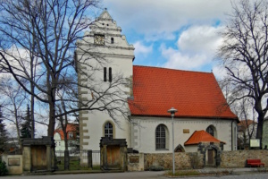 Weißes Kirchgebäude mit rotem Dach.