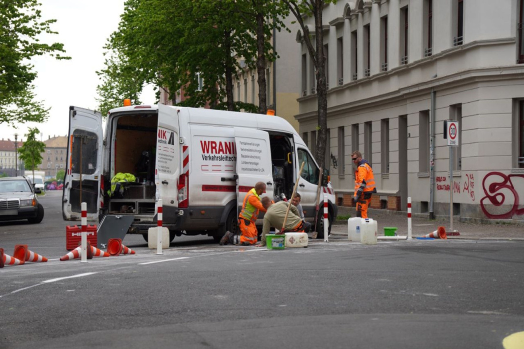 Transportwagen einer Fachfirma, Bauarbeiter auf der Straße.