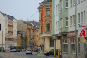 Hauptstraße in der Stadt mit Wohnhäusern und Geschäften.