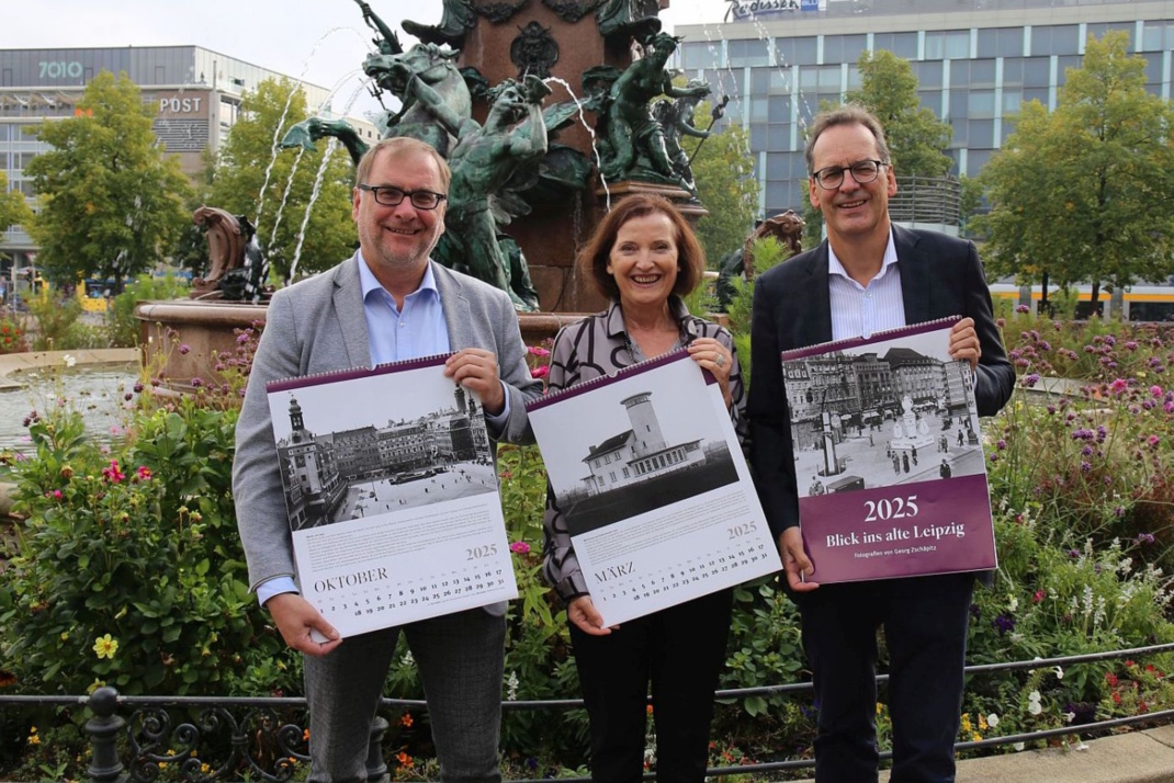 Dr. Anselm Hartinger (Direktor des Stadtgeschichtlichen Museums Leipzig), Marit Schulz (Prokuristin der LTM GmbH) und Volker Bremer (Geschäftsführer der LTM GmbH) präsentieren den Historischen Leipzig-Kalender 2025 auf dem Augustusplatz – Foto: Andreas Schmidt