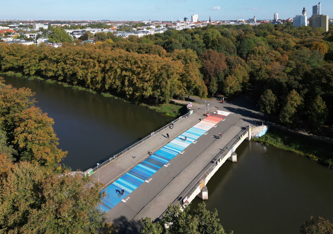 Brücke mit Warming Stripes aus der Vogelperspektive.