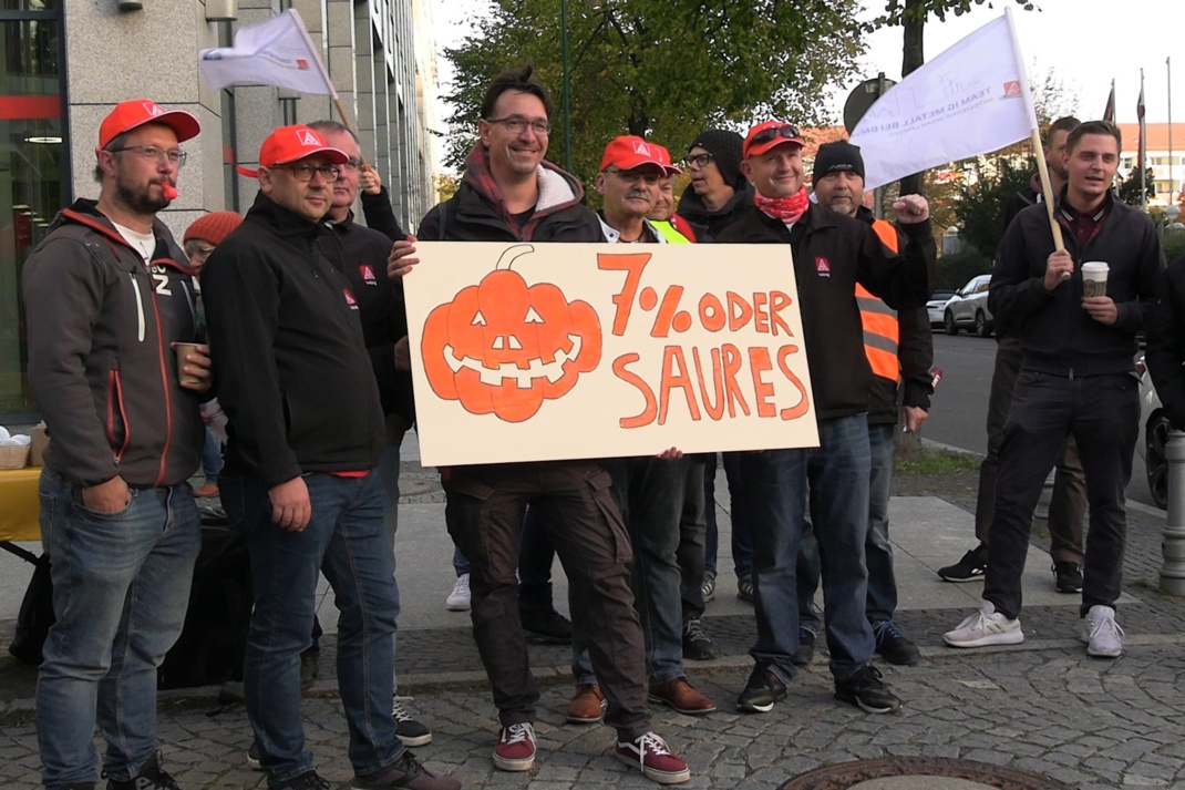 Demo zu Tarifverhandlungen, Teilnehmer mit Schild.