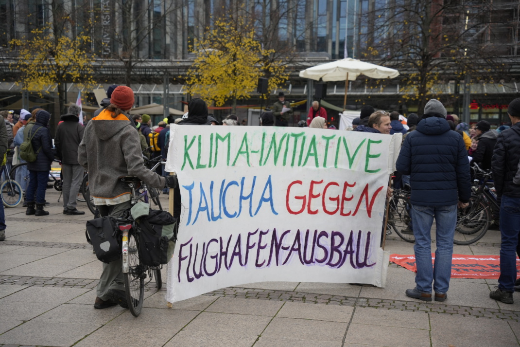 Demoi gegen Flughafenausbau, Teilnehmer halten Transparent.