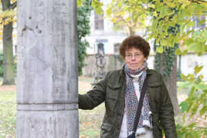 Katrin Löffler steht an der Grabsäule auf dem Alten Johannisfriedhof.