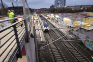 S-Bahn steht im beleuchteten Bahnhof während der Dämmerung, Aufnahme von vorn oben.