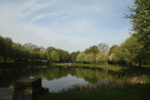 Das Bassin in der Anton-Bruckner-Allee, umgeben von Grün und blauem Himmel mit Wolken.