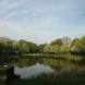 Das Bassin in der Anton-Bruckner-Allee, umgeben von Grün und blauem Himmel mit Wolken.