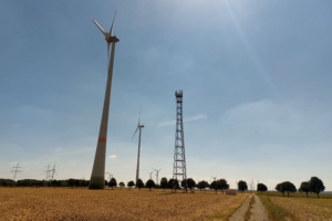 Windräder in der Landschaft, Sonne und blauer Himmel.