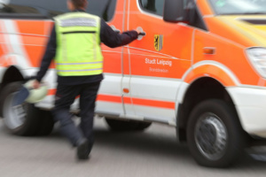 Verschwommenes Bild, Angehöriger der Feuerwehr öffnet die Tür zu einem Rettungsfahrzeug.