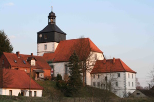 Kirche auf einer Anhöhe, aus der Distanz fotografiert.