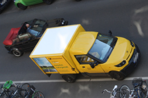 Postwagen steht auf der Straße, Aufnahme von schräg oben.