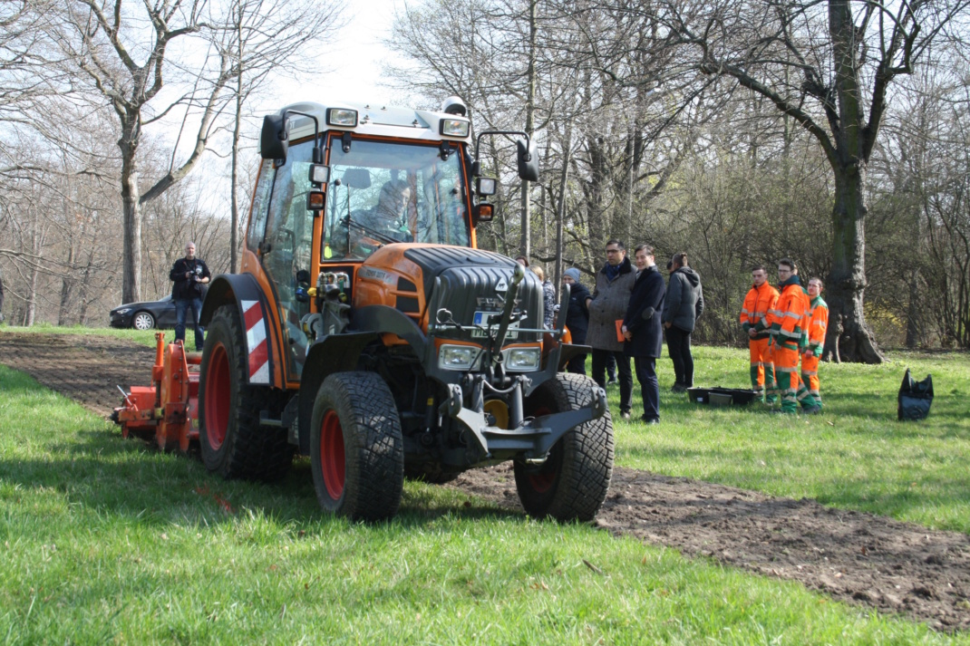 Trecker auf Grünfläche im Einsatz.