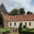 Helles Kirchengebäude mit Friedhof.