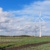 Windkraftanlage auf freiem Feld, blauer Himmel und Wolken.