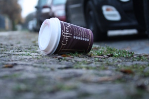 To-go-Becher im Leipziger Straßenbild, Nahaufnahme auf dem Bürgersteig.